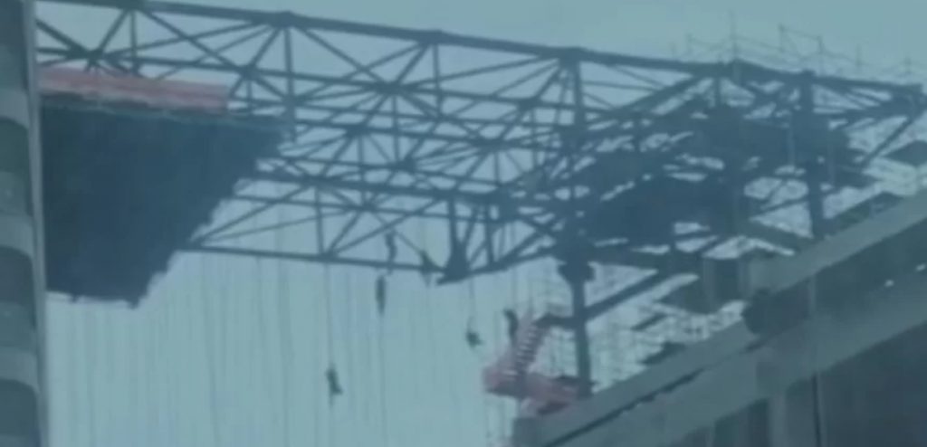 Imagem mostra trabalhadores presos por cabos em construção um operário morre ao cair de andaime  - Metrópoles