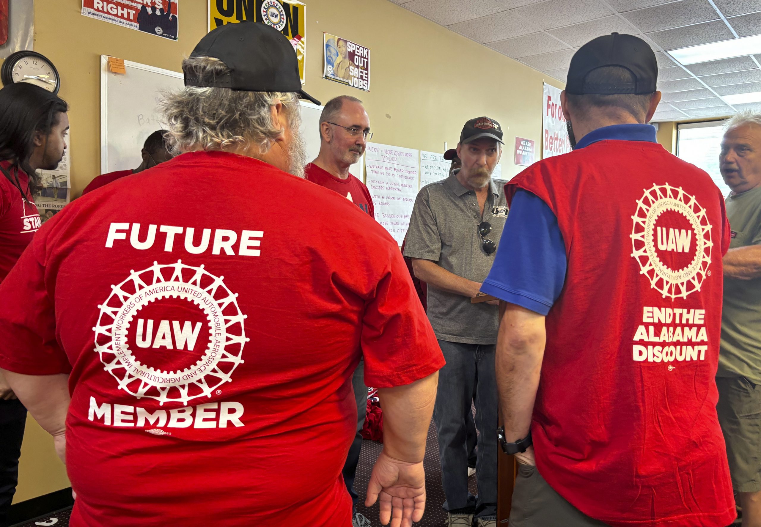 O presidente da UAW, Shawn Fain, ao centro, conversa com trabalhadores da Mercedes no Alabama. O sindicato está lutando para anular a derrota na eleição, que, segundo eles, resultou de violações da lei pela empresa. Foto: Reprodução People´s World